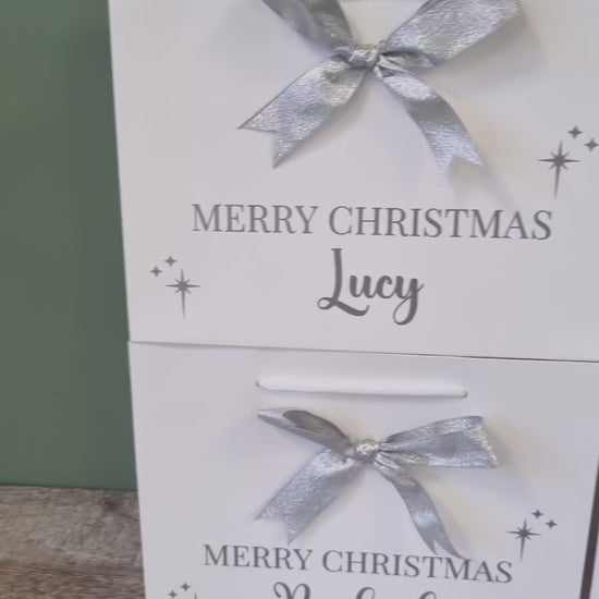 Personalised gift bag in white with silver  writing and matching silver bow. 