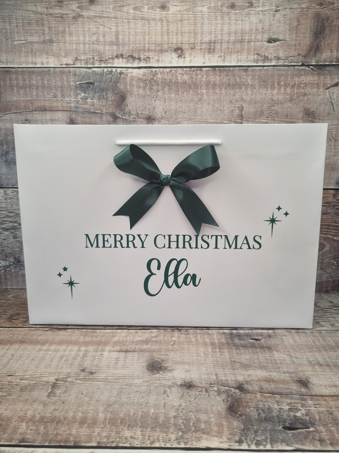 Personalised gift bag in white with dark green writing and matching satin bow. 