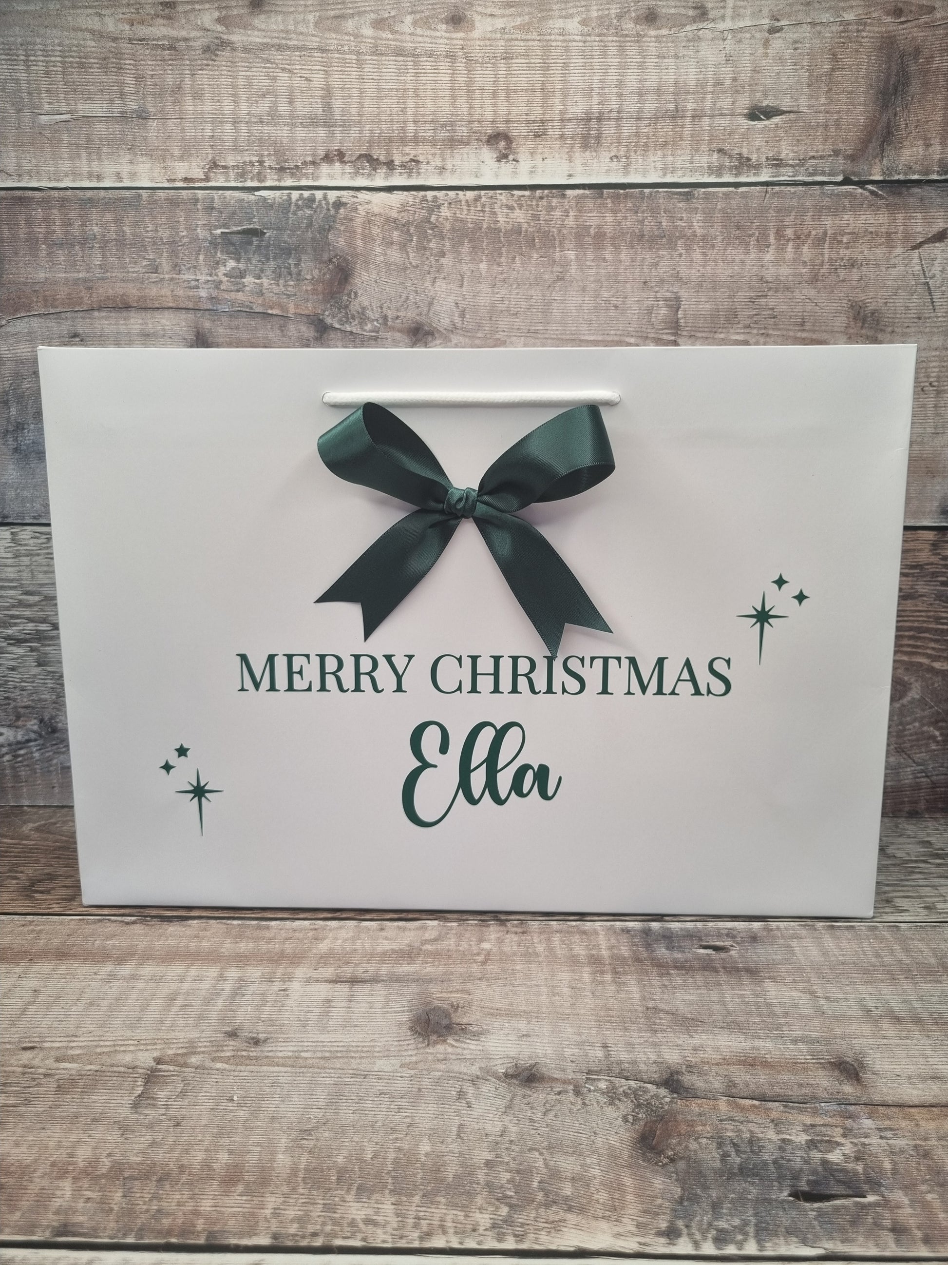 Personalised gift bag in white with dark green writing and matching satin bow. 