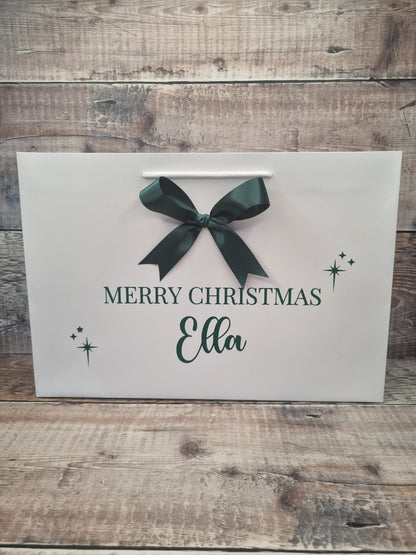 Personalised gift bag in white with dark green writing and matching satin bow. 