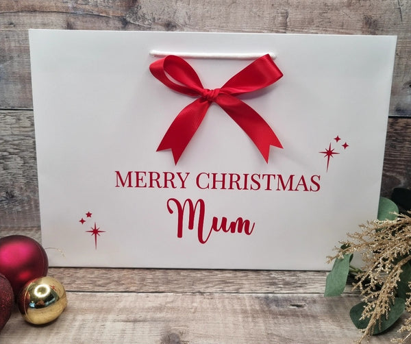 Personalised gift bag in white with red writing and matching red satin bow. 